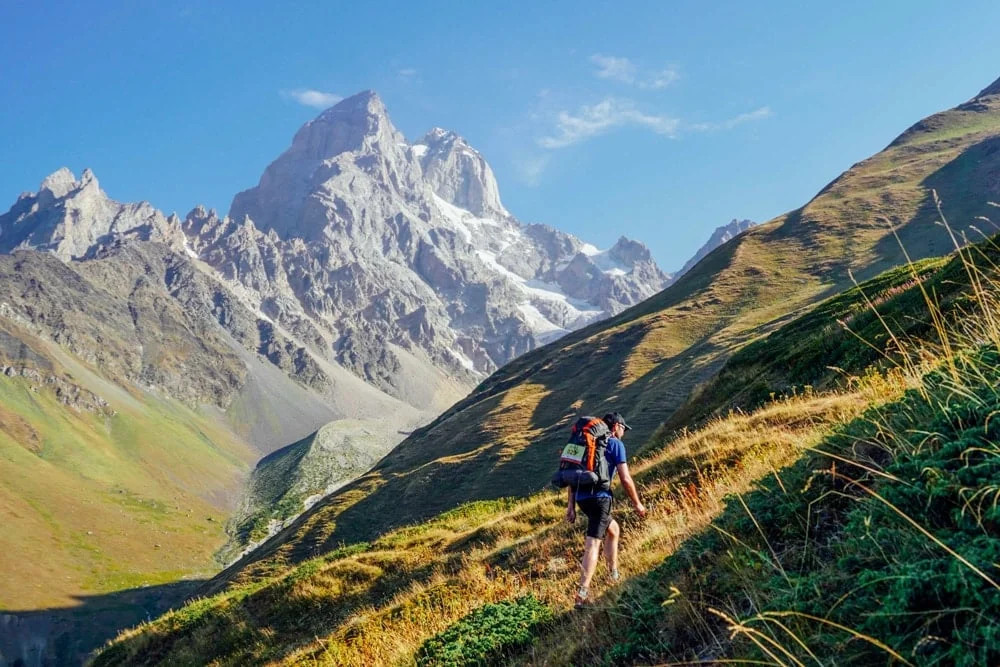 Hiker wearing down jacket and hiking boots on trail