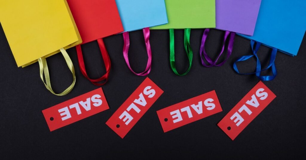 Colorful shopping bags with sale tags on a dark background