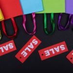 Colorful shopping bags with sale tags on a dark background