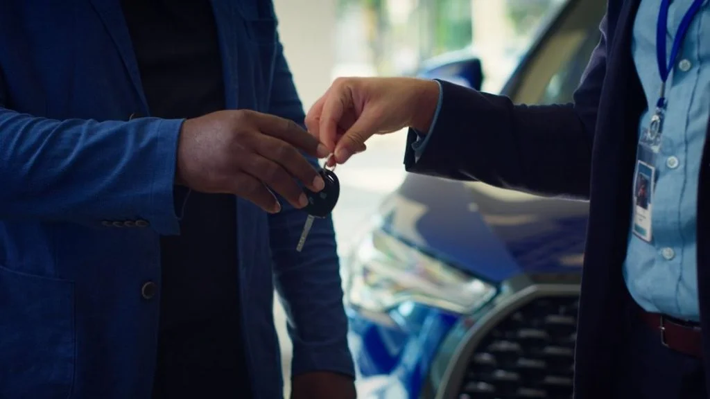 Person reviewing car finance papers at dealership desk