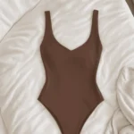 SKIMS one-piece laid flat on white bedding, the brand behind the 25% loyalty event