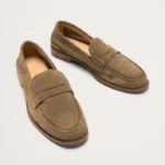 Pair of brown suede penny loafers on white background
