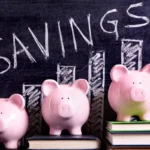 Three pink piggy banks on books beside a savings chart
