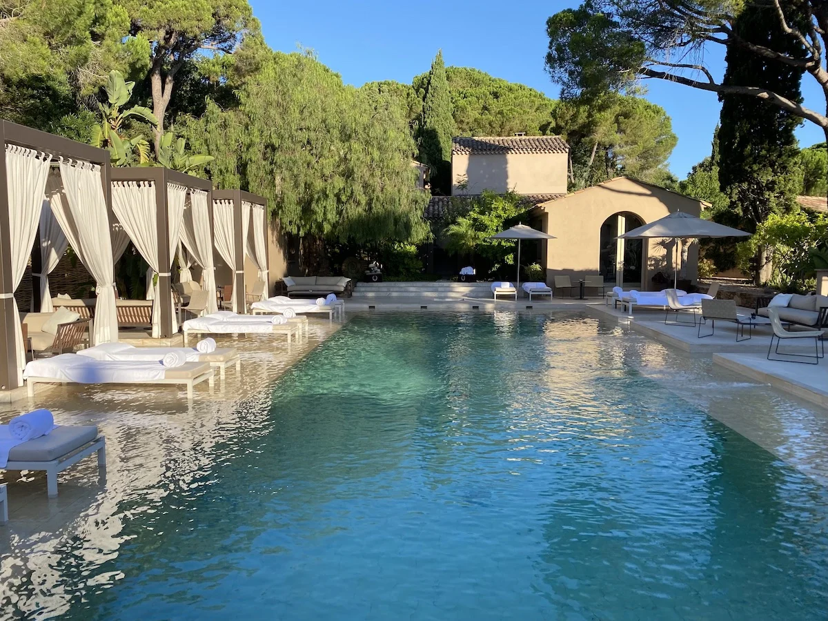 Luxury resort pool with loungers in a garden