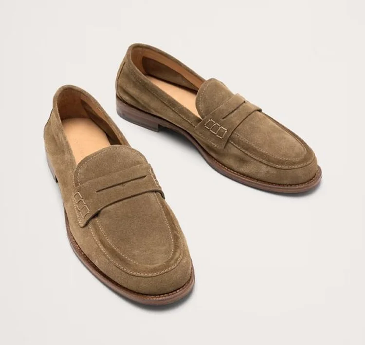 Pair of brown suede penny loafers on white background