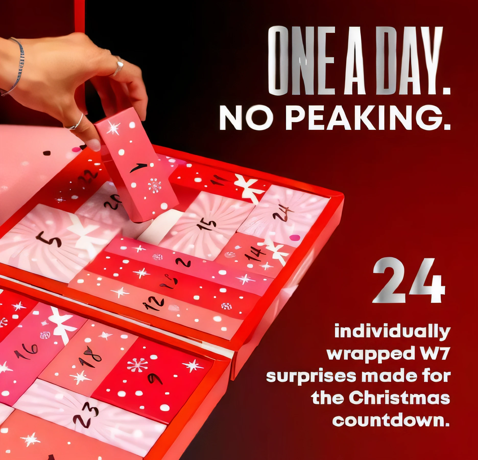 Hand pulling a numbered tile from a W7 beauty advent calendar